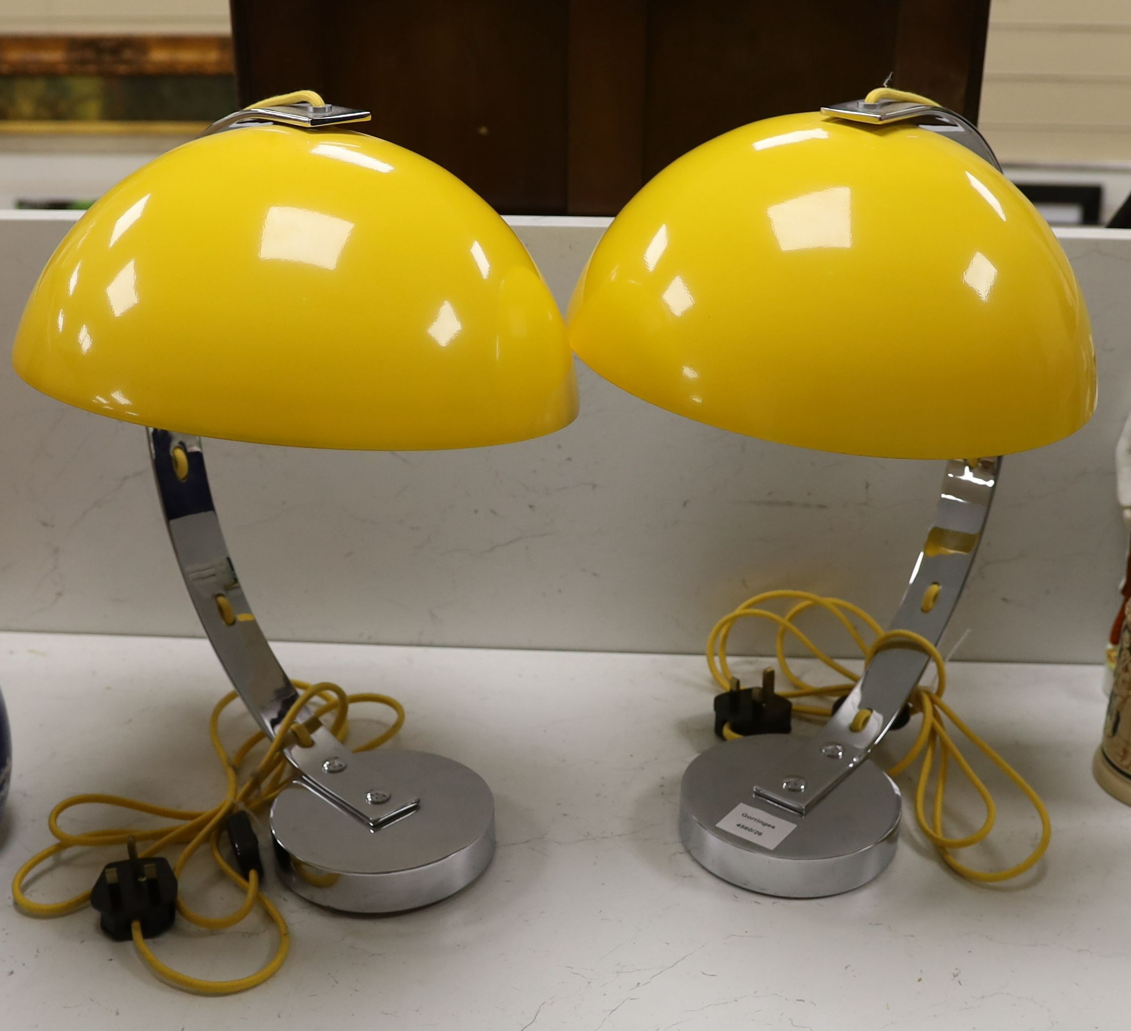 A pair of contemporary chrome reading lamps with yellow glass domed shades, 46 cms high.